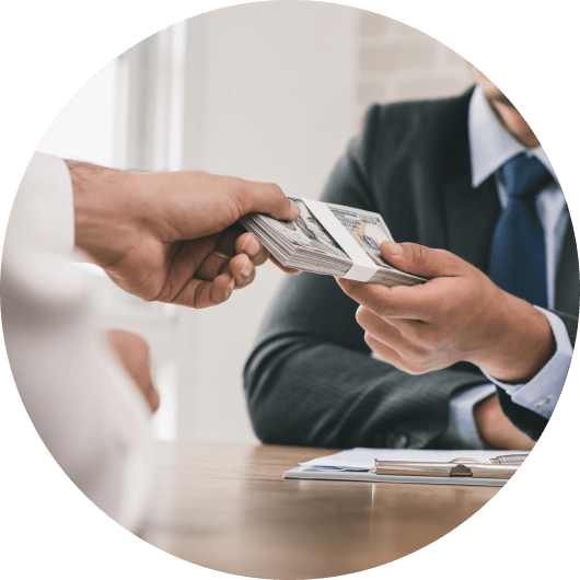 Loan agent handing a bundle of US dollars to a business loan applicant during approval process
