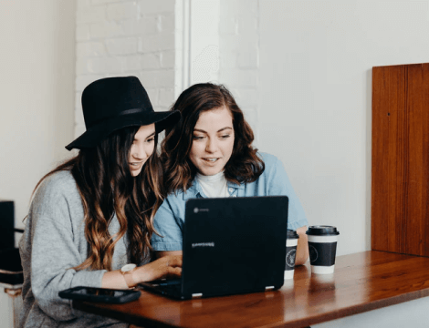 Two loan agents looking at a computer screen while reviewing green energy loans for business clients.