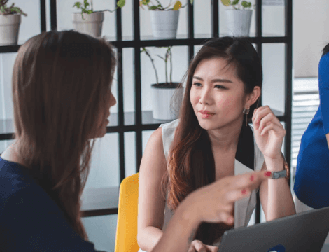 Applicant seated with loan agent discussing business loan options in a friendly office setting.