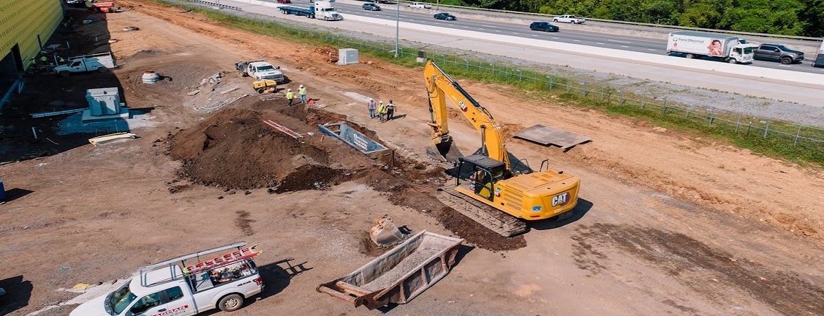 Excavator and truck parked in front of Saudi Arabia business loans office building